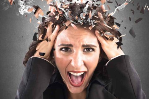 Woman holding head, screaming in stress