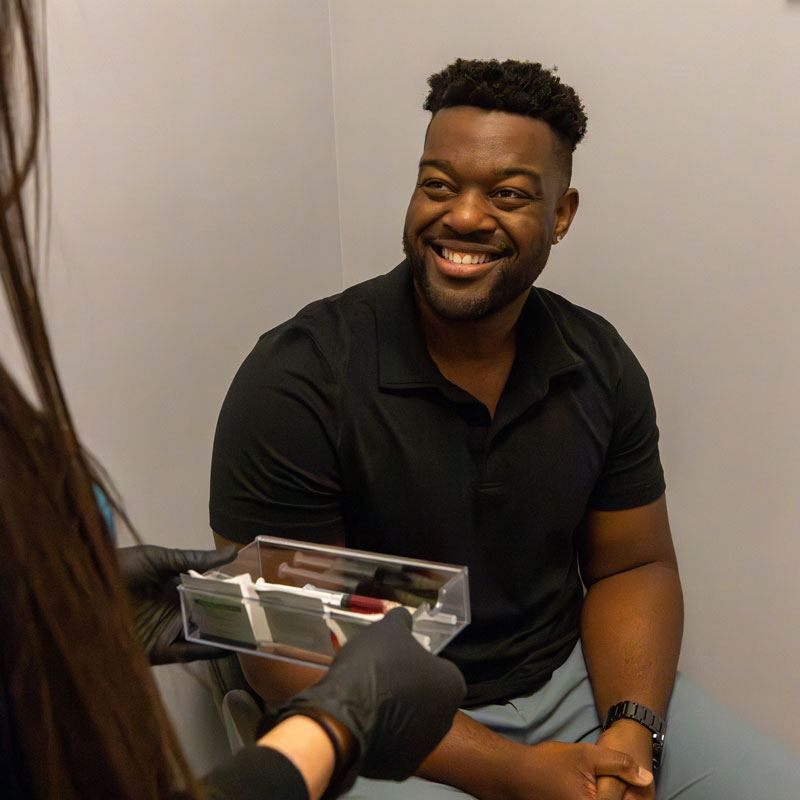 man smiling with worker holding tray of injections at Vital Hydration of Knoxville, TN